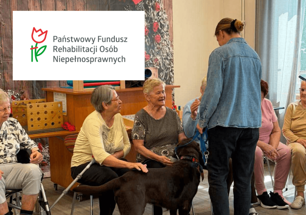 Seniorki podczas zajęć z dogoterapii z pieskiem oraz logo PFRON w lewym górnym rogu.